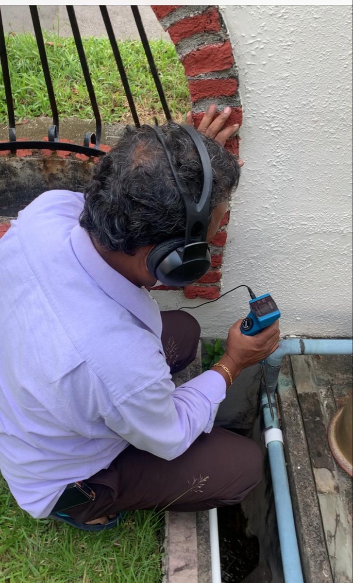Our technician inspecting a wall pipe on a Singapore job site